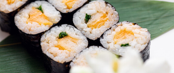 Sushi rolls served on a wooden plate in a restaurant