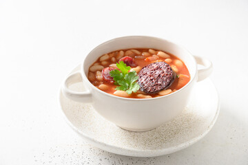 Spanish traditional fabada with haricot, morcilla, chorizo on white background. Close up. Asturiana cuisine