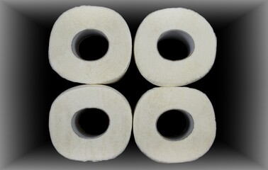 Four rolls of toilet paper. Top view. A square of toilet paper. Vignetting effect. White corridor