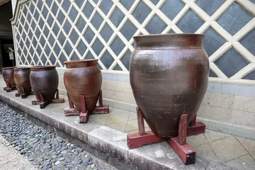 Fotobehang 日本の古い蔵の前の沢山の壺の風景 © masamasa3