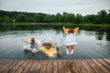 Children having fun on a lake jumping into water