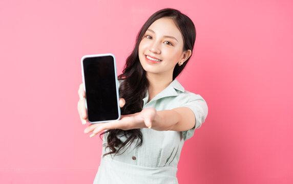 Young Asian Woman Holding Phone In Hand And Holding It Forward