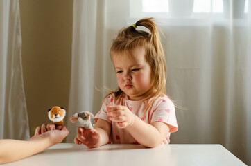 Child playing theater with animal finger puppets. Role-playing games and activities for expressing...