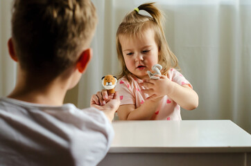 Child playing theater with animal finger puppets. Role-playing games and activities for expressing...