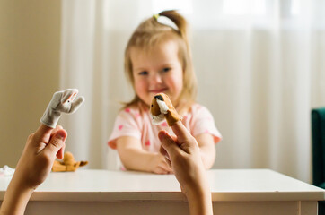 Child playing theater with animal finger puppets. Role-playing games and activities for expressing...