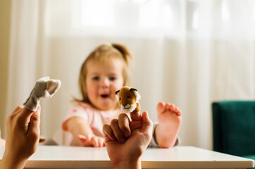 Child playing theater with animal finger puppets. Role-playing games and activities for expressing...