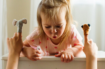 Child playing theater with animal finger puppets. Role-playing games and activities for expressing...