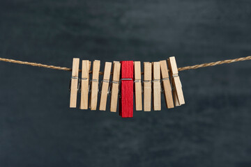 Wooden clothespins on a rope. Not like everyone. Difference from others.