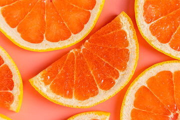 Group of fresh organic grapefruit slices over pink background. Flat lay.