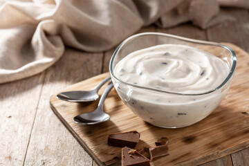 Stracciatella yogurt in transparent bowl on wooden table