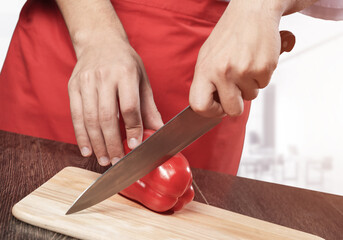 Chef hands cutting red fresh pepper