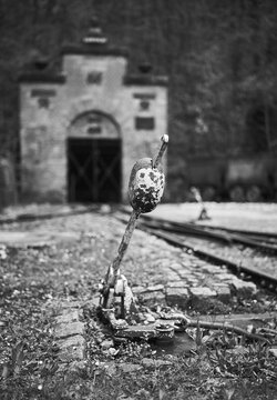 Vertical grayscale shot of a railway switch lever