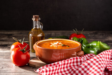 Gazpacho soup in crock pot and ingredient on wooden table