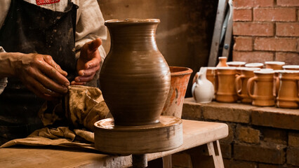 Potter hands making in clay on pottery wheel. Potter makes on the pottery wheel clay pot. Authentic pottery workshop