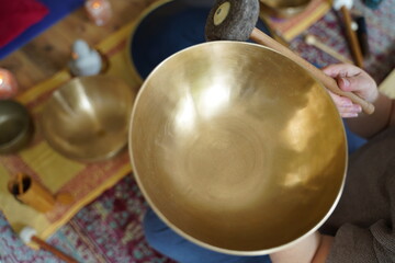 Caucasian woman holding a Tibetan singing bowl in her hand for sound healing therapy 