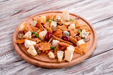 Cheese plate Assortment of various types of cheese on wooden cutting board on wooden background. Photo for the menu and site. Space for text