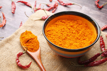 Chili powder and dried peppers on table background.