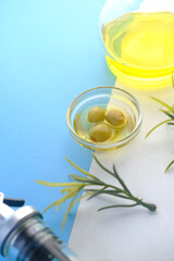 bottle of olive oil and fresh olive in a container on color background .
