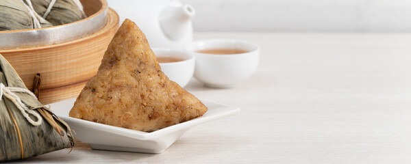 Zongzi. Rice dumpling for Dragon Boat Festival on bright wooden table background.