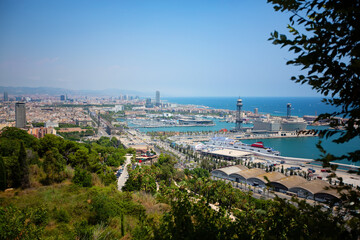 Obraz premium View from the height of the city of Barcelona in Spain. Sunny day. Urban landscape. View of the port and the sea.