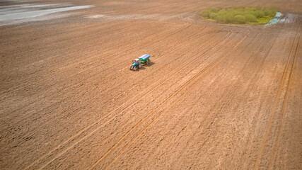Photo from a tractor drone sowing seeds in a field. Process of planting seeds in the ground as part of an early spring agricultural activity