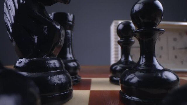 Look between the chess pieces. Two chess players man and woman play chess. Debut Accepted Queen's Gambit, King's Gambit, Philidor's Defense. Cinematic filming of a chess game. Laowa macro.