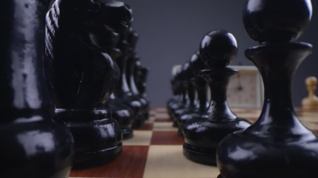 Look between the chess pieces. Two chess players man and woman play chess. Debut Accepted Queen's Gambit, King's Gambit, Philidor's Defense. Cinematic filming of a chess game. Laowa macro.