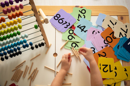 Little caucasian girl studying numbers and math in the classroom, stylish interior for home education, preschool child education, home schooling