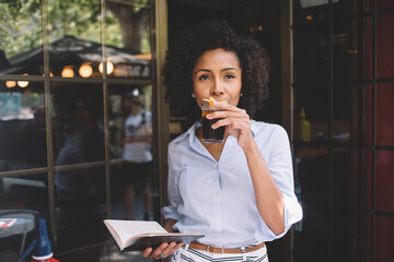 African American businesswoman with organizer enjoying cocktail