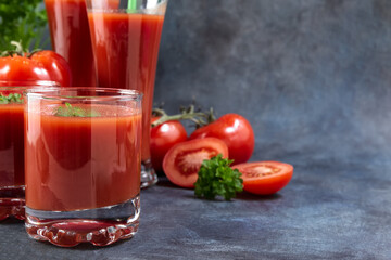 Tomato juice. Tomatoes and tomato juice in glasses on vintage background.