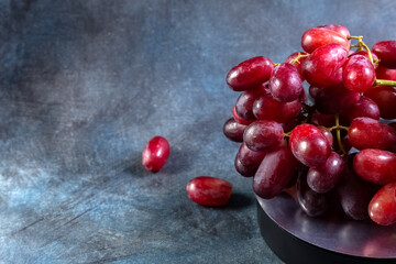 Red grapes on a blue vintage background. Copy space.