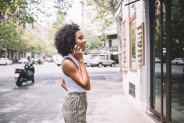 Happy woman speaking on cellphone on street