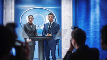 Female and Male Organization Representatives Speaking at Press Conference in Government Building. Press Officers Delivering a Speech at Summit. Ministers Speaking at Congress Hearing.