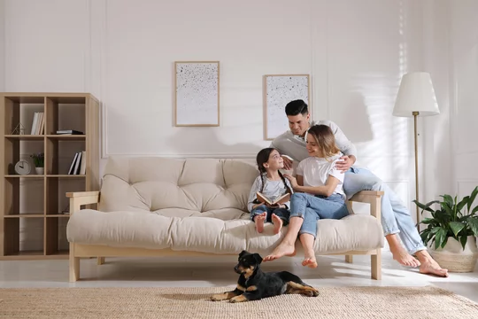 Happy family on sofa with puppy in living room