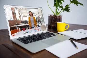 Asian woman having business video call on screen of laptop on desk