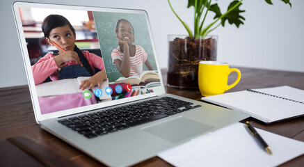 Laptop computer with a video call from diverse children lying on desk