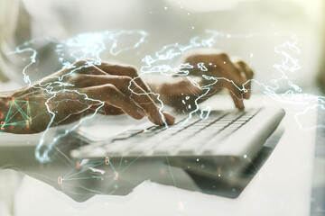 Abstract creative digital world map and hands typing on laptop on background, globalization...