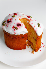 Easter muffin cake with pistachios and cranberry and easter decorations on a white plate. White background. Copy space. 