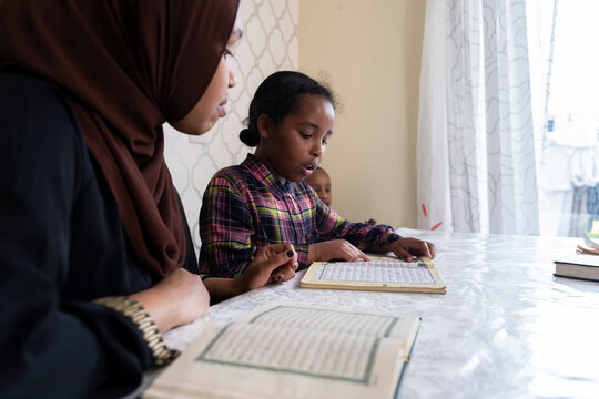 Mother and children reading quran together