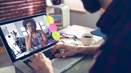 Caucasian businessman sitting at desk using laptop having video call with female colleague