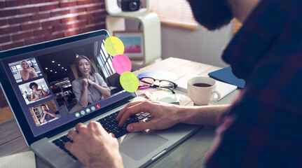 Caucasian businessman sitting at desk using laptop having video call with group of colleagues