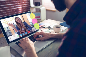 Caucasian businessman sitting at desk using laptop having video call with female colleague