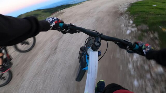 POV Gloved mountain biker riding fast downhill on a macadam path and falling to the ground on a sharp curve