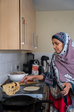 Black Muslim Woman Making Chapati In The Kitchen