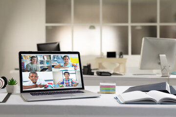 Diverse pupils having online lesson on screen of laptop on desk