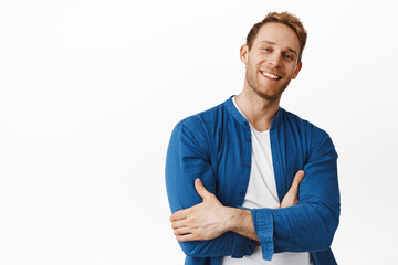 Cool handsome redhead man, smiling with confidence, cross arms on chest and looking happy...