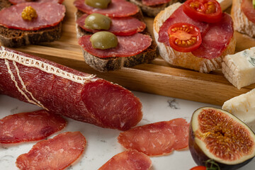 Assortment of sausages and cheese, salami, olives, on white background. Close up
