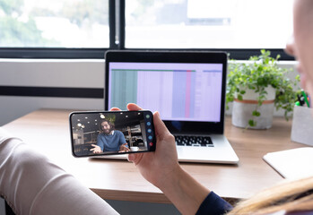 Caucasian woman using smartphone having video call with coworker