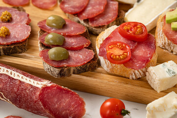Assortment of sausages and cheese, salami, olives, on white background. Close up