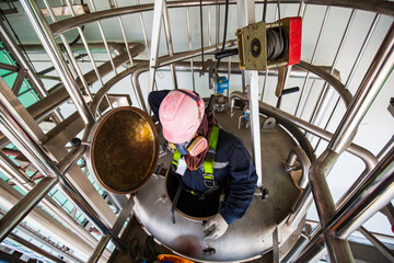 Top view male climb up the stairs into the tank stainless chemical